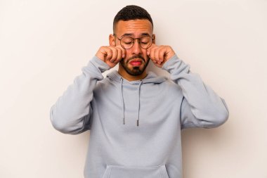 Beyaz arka planda yalnız kalmış, ağlayan ve sızlanan genç bir İspanyol..