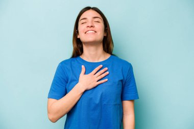 Mavi arka planda yalnız yaşayan beyaz bir kadın elini göğsüne koyduğunda kahkahalar atıyor..