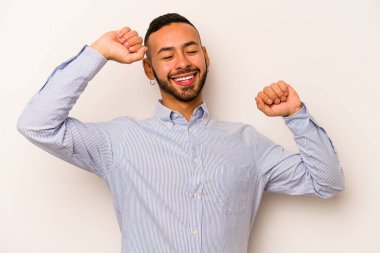 Beyaz arka planda izole edilmiş genç bir İspanyol özel bir günü kutluyor, atlıyor ve enerjiyle kollarını kaldırıyor..