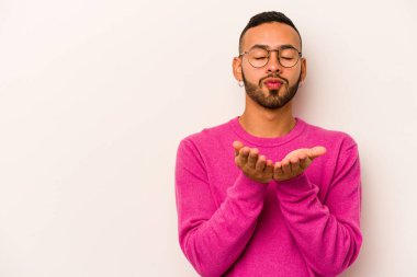 Beyaz arka planda izole edilmiş, dudakları kıvrılmış ve hava öpücüğü yollamak için avuç içi tutan İspanyol bir adam..