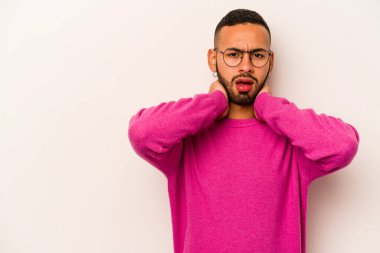 Genç İspanyol bir adam beyaz arka planda izole edilmiş kafasının arkasına dokunuyor, düşünüyor ve bir seçim yapıyor..