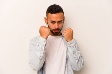 Latin kökenli genç bir adam beyaz arka planda izole edilmiş. Yumruk atıyor, sinirleniyor, kavga ediyor..