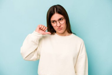 Mavi arka planda izole edilmiş genç beyaz bir kadın hoşlanmadığı bir jest gösteriyor, kabul etmiyor. Anlaşmazlık konsepti.