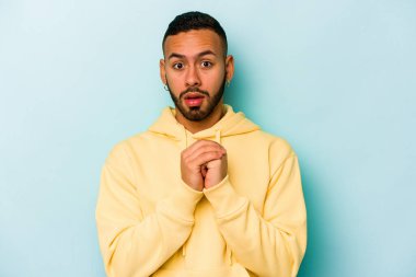 Genç İspanyol adam mavi arka planda izole edilmiş korkmuş ve korkmuş..