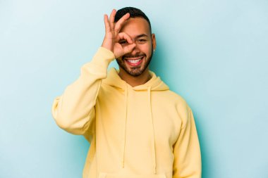 Latin kökenli genç adam mavi arka planda izole edilmiş. Heyecanlı..
