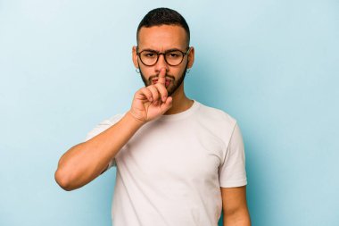 Genç İspanyol adam mavi arka planda izole edilmiş düşünüyor, bakıyor, yansıtıyor, düşünüyor, hayal kuruyor..