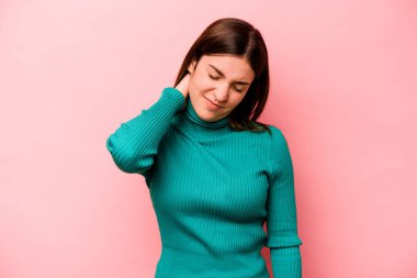 Genç, beyaz bir kadın pembe arka planda izole edilmiş. Durağan yaşam tarzından dolayı boyun ağrısı çekiyor..