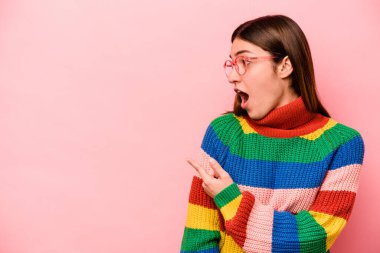 Pembe arka plan noktalarında izole edilmiş genç beyaz kadın başparmak uzakta, gülüyor ve kaygısız..