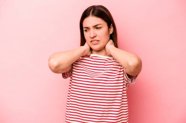 Genç, beyaz bir kadın pembe arka planda izole edilmiş. Durağan yaşam tarzından dolayı boyun ağrısı çekiyor..