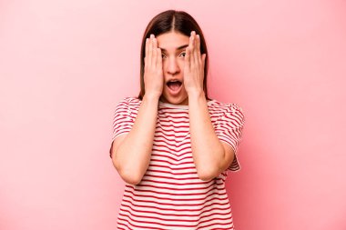 Pembe arka planda izole edilmiş beyaz bir kadın yüzünün yarısını palmiye ile örterek eğleniyor..