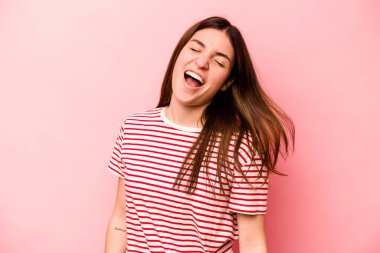 Genç beyaz kadın pembe arka planda izole edilmiş dans ediyor ve eğleniyor..