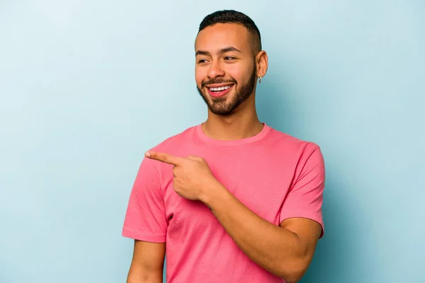 Jonge Spaanse Man Geïsoleerd Blauwe Achtergrond Kijkt Opzij Glimlachend Vrolijk — Stockfoto