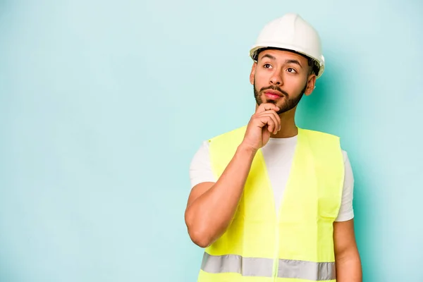 Young Laborer Hispanic Man Isolated Blue Background Looking Sideways Doubtful — 스톡 사진