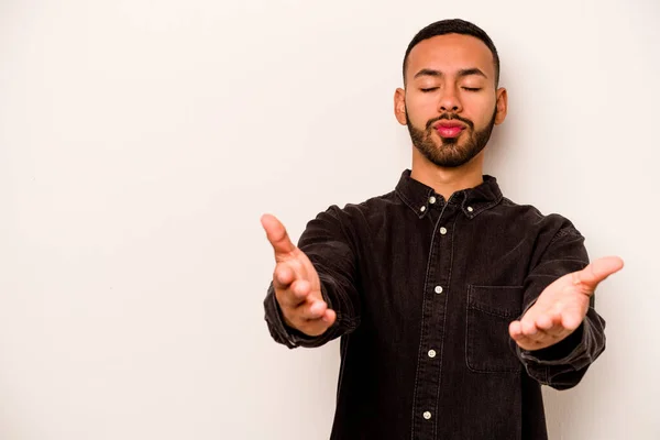 Joven Hispano Aislado Sobre Fondo Blanco Doblando Labios Sosteniendo Palmas —  Fotos de Stock