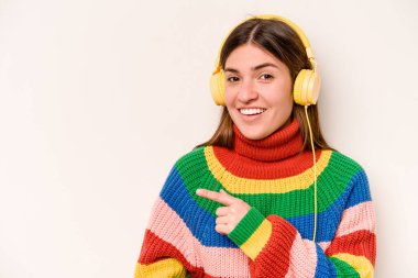 Beyaz arka planda izole edilmiş müzik dinleyen beyaz bir kadın gülümseyip işaret ediyor, boş alanda bir şeyler gösteriyor..