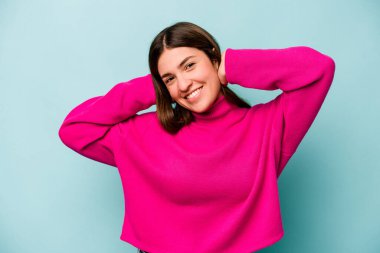 Mavi arka planda izole edilmiş genç beyaz kadın kollarını uzatıyordu, rahat bir pozisyondaydı..