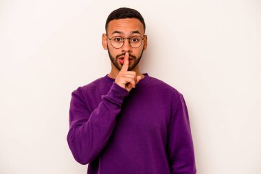 Beyaz arka planda izole edilmiş genç İspanyol bir adam ya sır saklıyor ya da sessizlik istiyor..