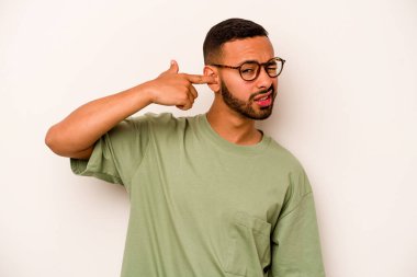 Beyaz arka planda izole edilmiş genç İspanyol adam kulaklarını elleriyle kapatıyor..