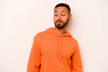 Beyaz arka planda izole edilmiş genç bir İspanyol omuz silkiyor ve gözleri açık..