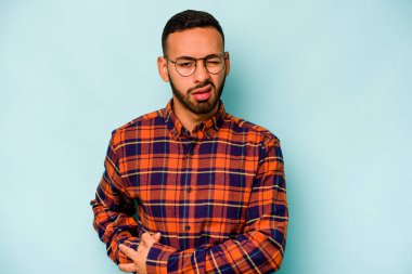 Mavi arka planda karaciğer ağrısı ve karın ağrısı çeken genç bir İspanyol..