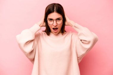 Pembe arka planda izole edilmiş genç beyaz kadın çığlık atıyor, çok heyecanlı, tutkulu, bir şeyden memnun..