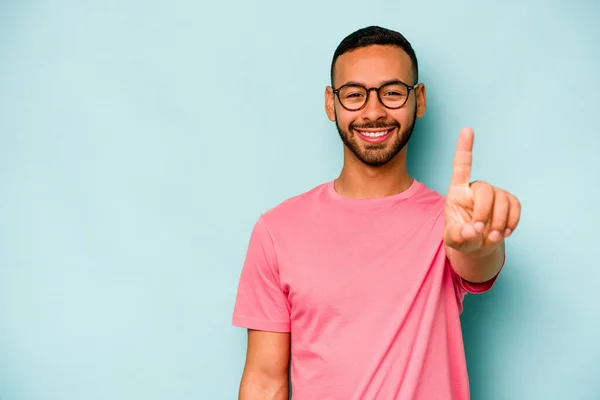 Jonge Latino Man Geïsoleerd Blauwe Achtergrond Tonen Nummer Een Met — Stockfoto