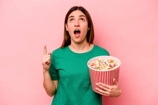 Giovane Donna Caucasica Possesso Popcorn Isolato Sfondo Rosa Che Punta — Foto Stock