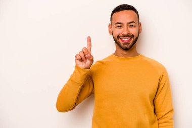 Beyaz arka planda izole edilmiş genç İspanyol bir numara parmağıyla görünüyor..