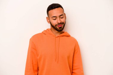 Beyaz arka planda izole edilmiş genç İspanyol adam gülüyor ve gözlerini kapıyor, rahatlamış ve mutlu hissediyor..