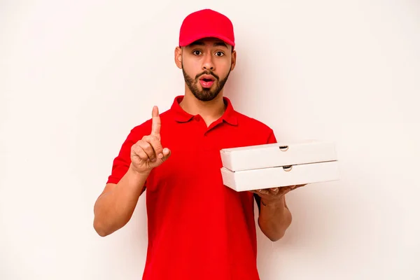 白い背景に孤立したピザを持っている若いヒスパニック系の配達人は いくつかの素晴らしいアイデアを持っています 創造性の概念 — ストック写真