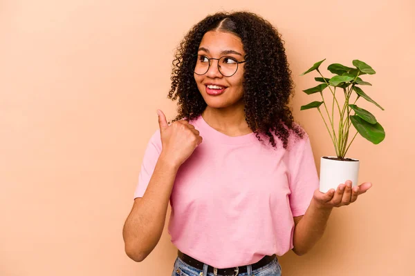 Young African American Woman Holding Plant Isolated Beige Background Points — 스톡 사진