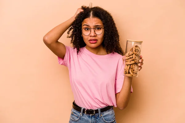 Young African American Woman Holding Cookies Jar Isolated Beige Background — Stockfoto