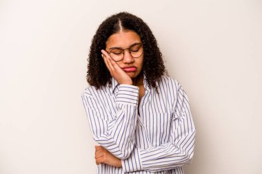 Beyaz arka planda izole edilmiş, sıkılmış, yorgun ve dinlenmeye ihtiyacı olan genç bir Afrikalı Amerikalı kadın..