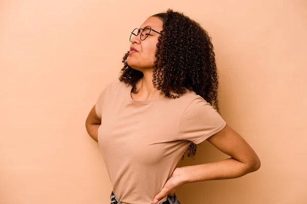 Ung Afrikansk Amerikansk Kvinna Isolerad Beige Bakgrund Lider Ryggsmärta — Stockfoto