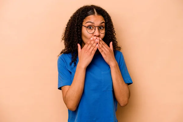 Νεαρή Αφροαμερικανή Γυναίκα Απομονωμένη Μπεζ Φόντο Σοκαρισμένη Καλύπτοντας Στόμα Χέρια — Φωτογραφία Αρχείου