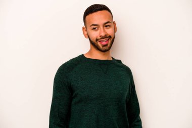 Beyaz arka planda izole edilmiş genç İspanyol adam gülüyor ve gözlerini kapıyor, rahatlamış ve mutlu hissediyor..