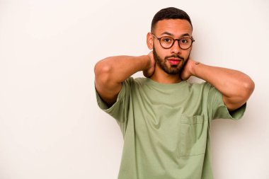 Genç İspanyol bir adam beyaz arka planda izole edilmiş kafasının arkasına dokunuyor, düşünüyor ve bir seçim yapıyor..