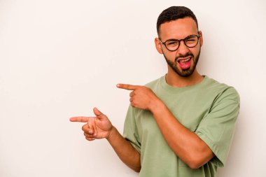 Beyaz arka planda izole edilmiş genç İspanyol adam işaret parmaklarıyla fotokopi alanını işaret ederek heyecan ve arzuyu ifade ediyor..