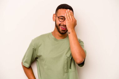 Beyaz arka planda izole edilmiş, yüzünün yarısını palmiye ile örterek eğlenen genç bir İspanyol..