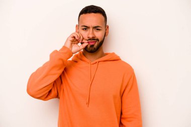 Beyaz arka planda izole edilmiş genç İspanyol adam parmakları dudaklarında bir sır saklıyor..