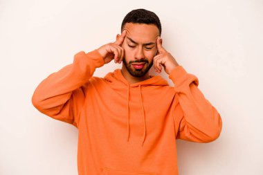 Beyaz arka planda izole edilmiş genç İspanyol bir adamın başı ağrıyor, yüzüne dokunuyor..