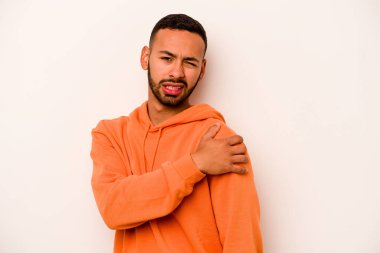 Beyaz arka planda izole edilmiş genç İspanyol bir adam omuz ağrısı çekiyor..