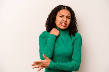 Genç Afrikalı Amerikalı kadın beyaz arka planda yalnız başına dirsek masajı yapıyor, kötü bir hareketin ardından acı çekiyor..