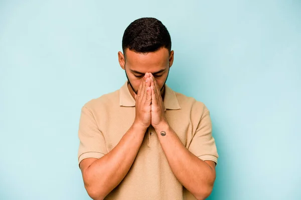 Νεαρός Ισπανός Απομονωμένος Μπλε Φόντο Προσευχόμενος Δείχνοντας Αφοσίωση Θρησκευόμενος Άνθρωπος — Φωτογραφία Αρχείου