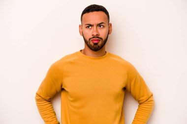 Beyaz arka planda izole edilmiş genç bir İspanyol kafası karışmış, kuşkulu ve güvensiz hissediyor..