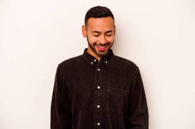 Beyaz arka planda izole edilmiş genç İspanyol adam gülüyor ve gözlerini kapıyor, rahatlamış ve mutlu hissediyor..