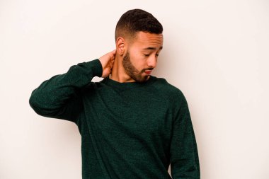 Beyaz arka planda izole edilmiş genç İspanyol bir adam stresten dolayı boynu ağrıyor, masaj yapıyor ve elle dokunuyor..