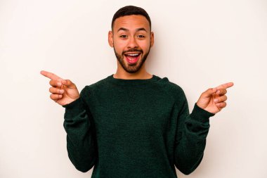 Beyaz arka planda izole edilmiş genç İspanyol adam farklı kopya alanlarını gösteriyor, birini seçiyor, parmaklarıyla gösteriyor..