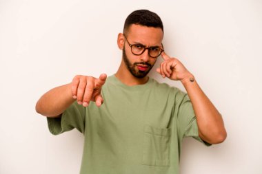 Beyaz arka planda izole edilmiş genç İspanyol bir adam şakağı parmağıyla işaret ediyor, düşünüyor ve bir göreve odaklanıyor..