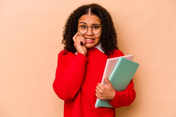 Jovem Estudante Afro Americano Mulher Isolada Fundo Bege Mordendo Unhas — Fotografia de Stock